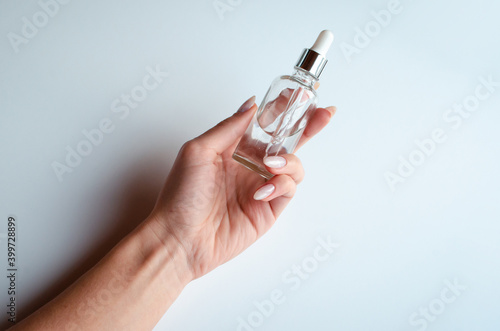 woman with beautiful marble manicure holding serum