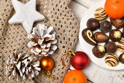 sweet food top view background for merry christmas or new year holiday decoration - chocolate candies, tangerines, cookies on white wood