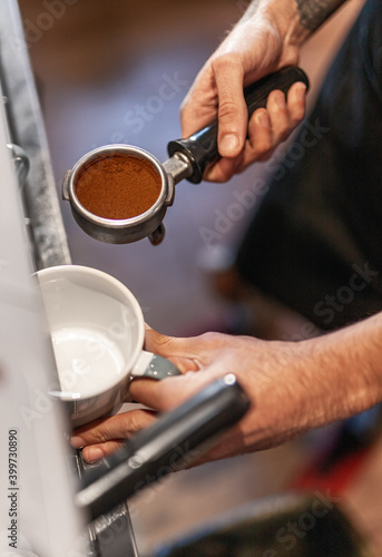 Barista with portafilter making coffee