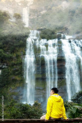 a man sitting in fronnt beautiful waterfall, paksong laos