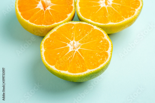 front view fresh tangerine slices on a light-blue background photo color orange citrus fruit