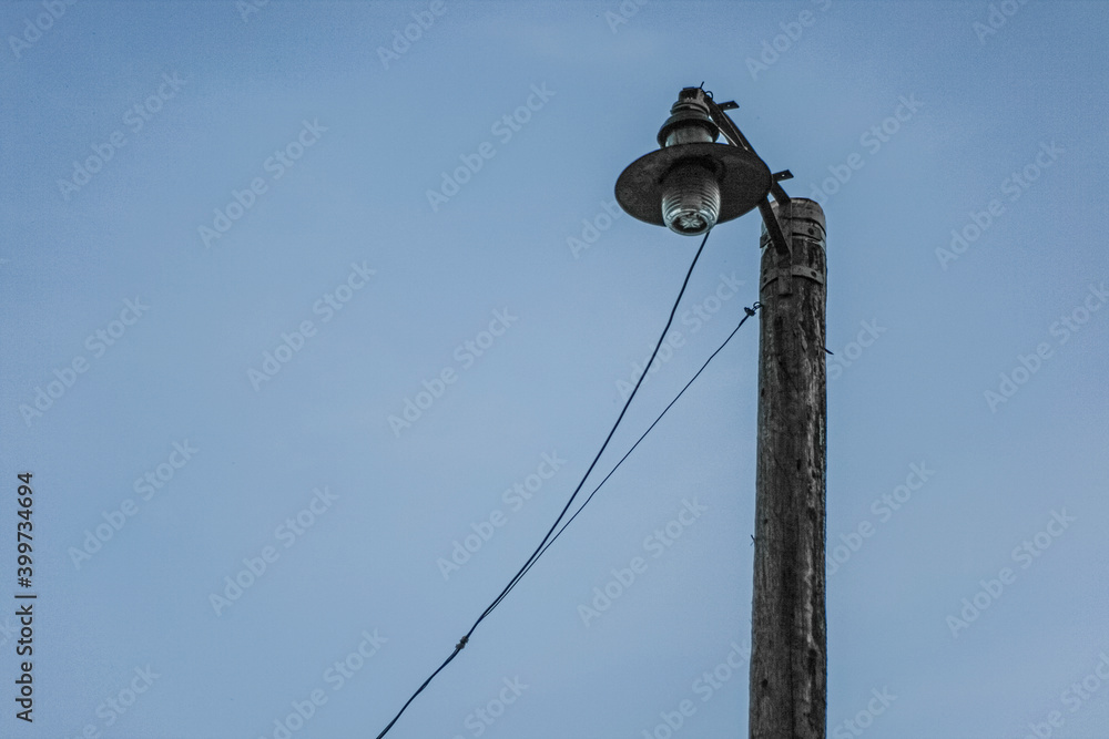 dark silhouette of an old rusty lamp post against dark blue sky in twilight dark silhouette of an old rusty lamp post against dark blue sky in twilight