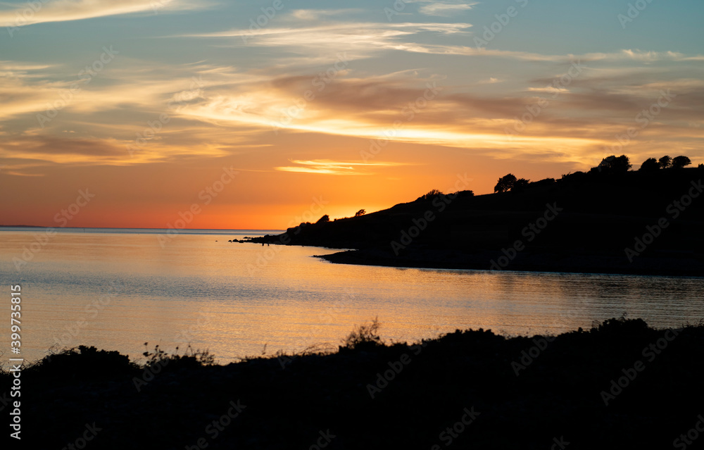 High contrast landscape at sunset with still ocean and a colourful sky