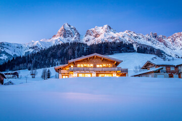 Wooden chalet in the alps on a cold winter evening