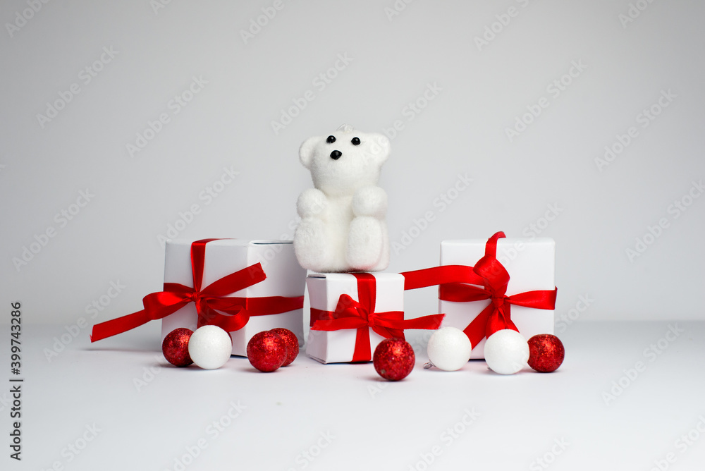 Festive background. white teddy bear is sitting near the red christmas hat isolated on white background. Christmas background. Santas hat and teddy bear