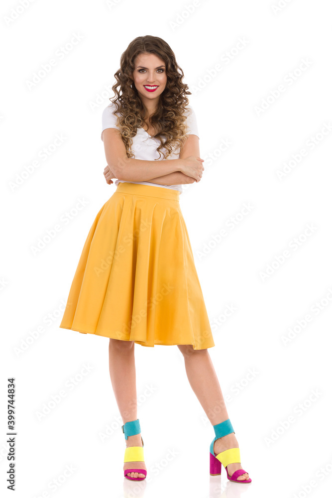 Smiling Young Woman In Yellow Skirt And Colorful High Heels. Front View.