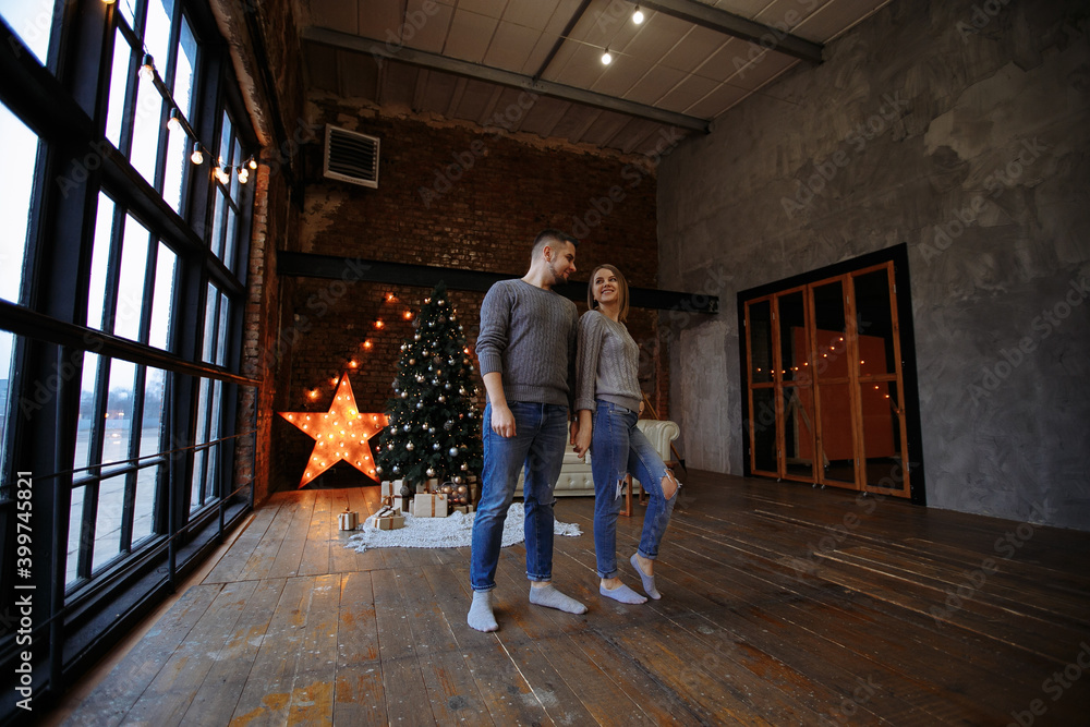 lovers in gray sweaters and jeans on the background of the Christmas tree lovers in gray sweaters and jeans on the background of the Christmas tree