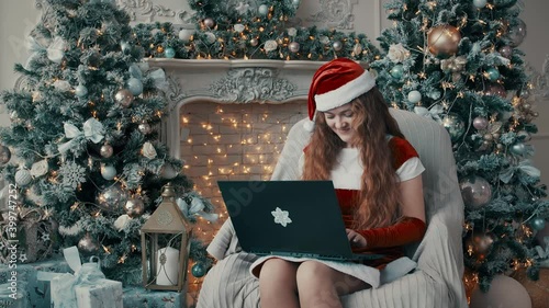A girl in a New Year's costume is typing on a laptop.