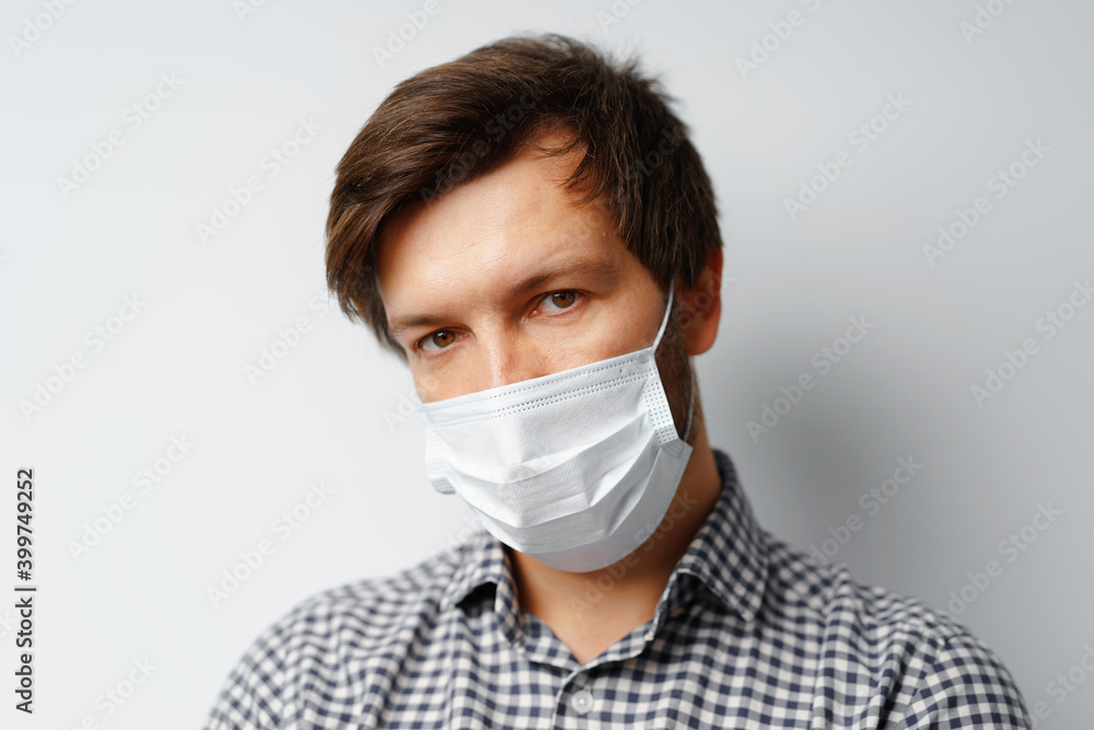 Man wearing hygienic mask against grey background Man wearing hygienic mask against grey background