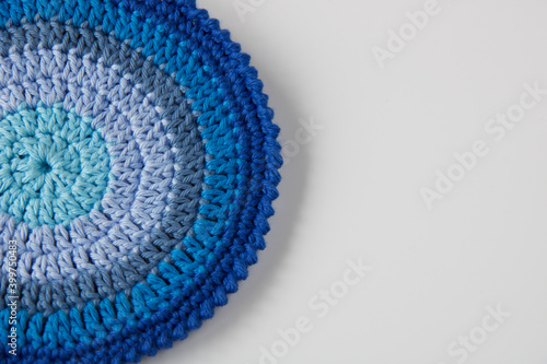 close up of handmade crochet pot holder in blue shades, copy space