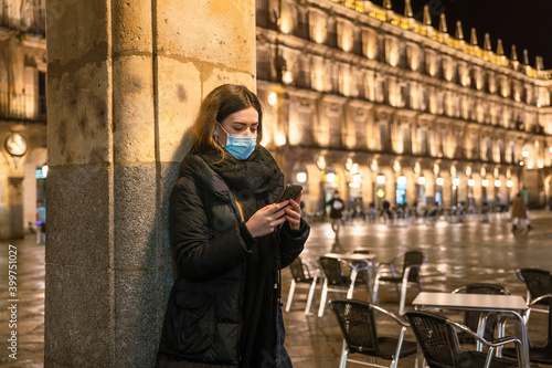 girl with phone and mask on street