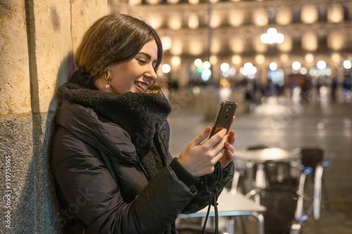 girl with phone on street at night