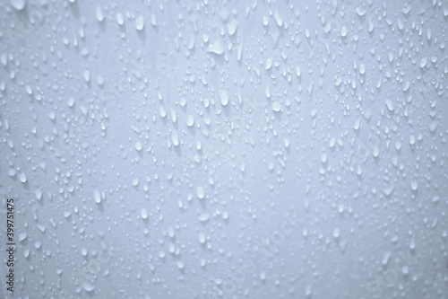 Blurred many water droplets on white bathroom wall with soft light for background backdrop photo