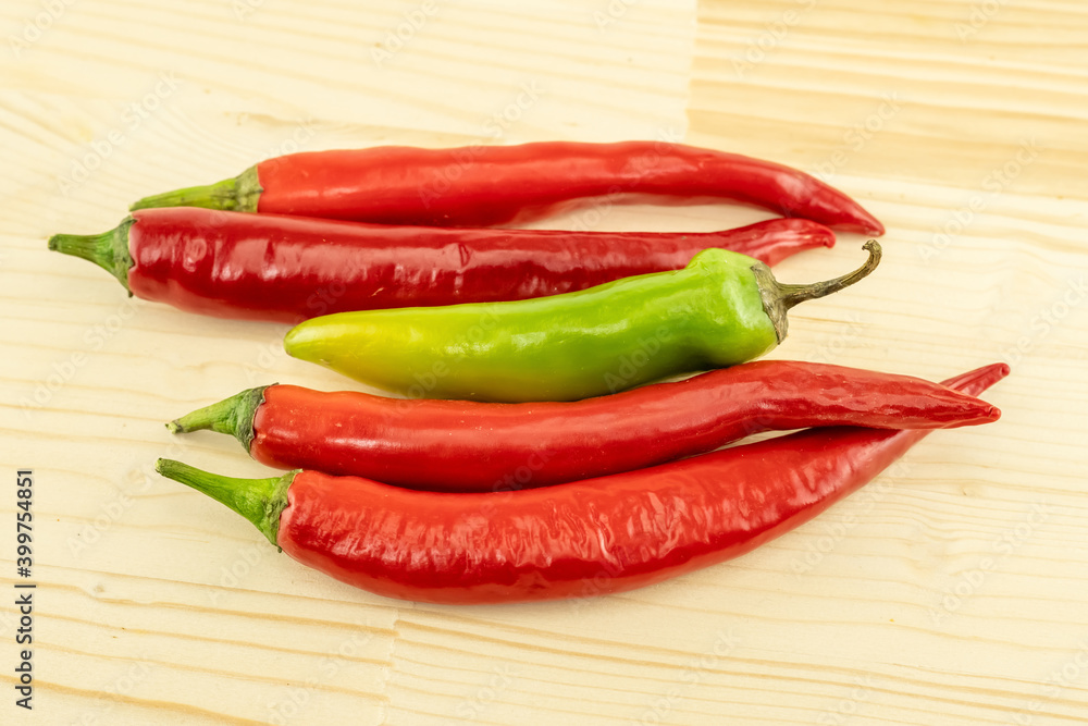 set of four horizontal chili peppers red and green pod nea wooden background