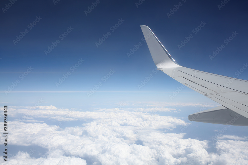 Widok z okna samolotu na chmury i skrzydło - obrazy, fototapety, plakaty 