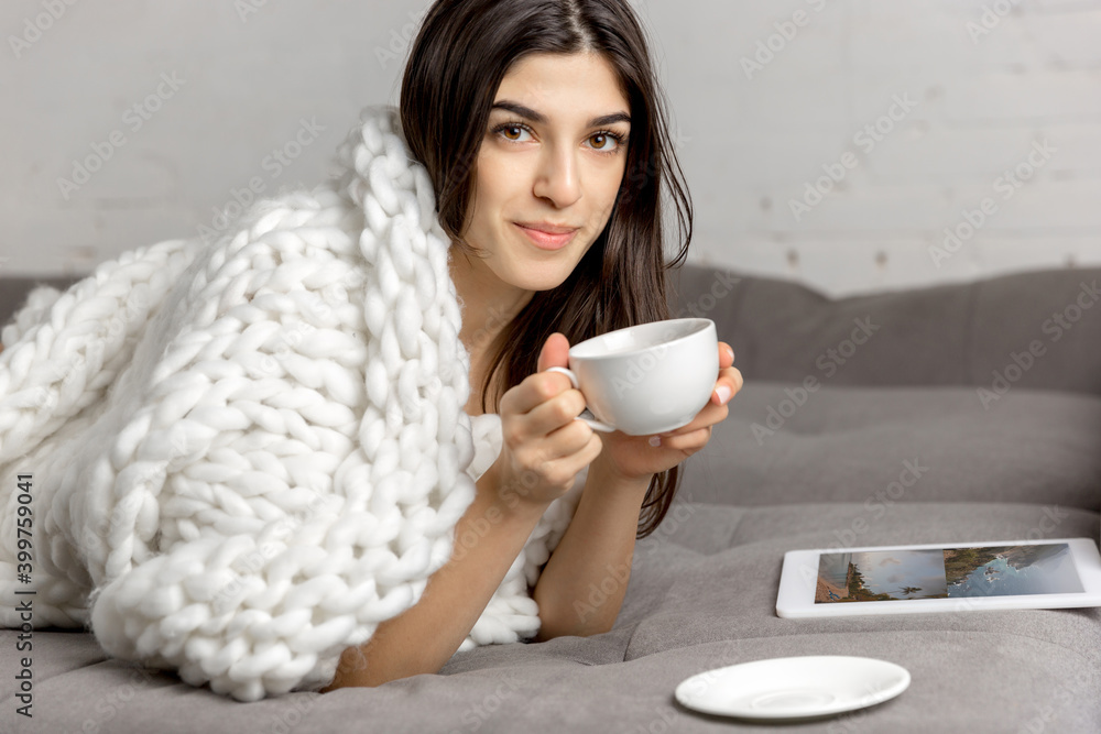 Drinking coffee wrapped in plaid. Portrait of beautiful brunette woman in comfortable soft longsleeve isolated on white studio background. Home comfort, human emotions, winter mood concept. Copyspace. Drinking coffee wrapped in plaid. Portrait of beautiful brunette woman in comfortable soft longsleeve isolated on white studio background. Home comfort, human emotions, winter mood concept. Copyspace.
