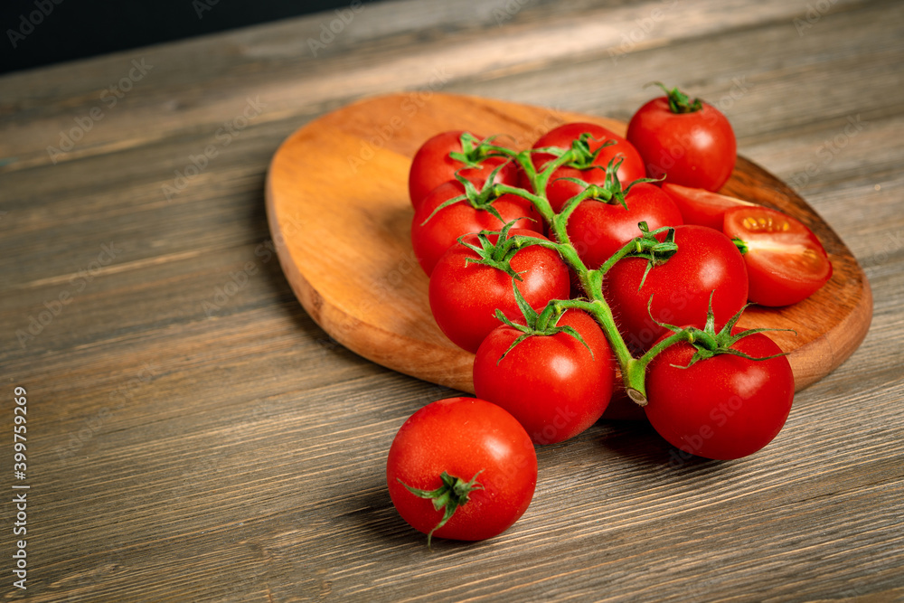Cherry tomatoes on a branch on a wooden board Cherry tomatoes on a branch on a wooden board
