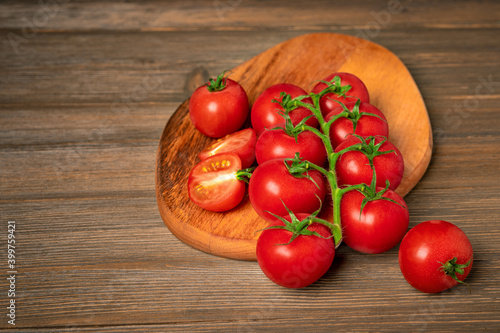 Cherry tomatoes on a branch on a wooden board