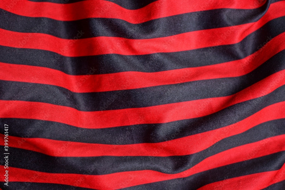 Fototapeta premium colored texture of crumpled striped synthetic red black fabric