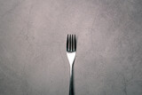 Bright Silver colored fork cutlery isolated on a grey background