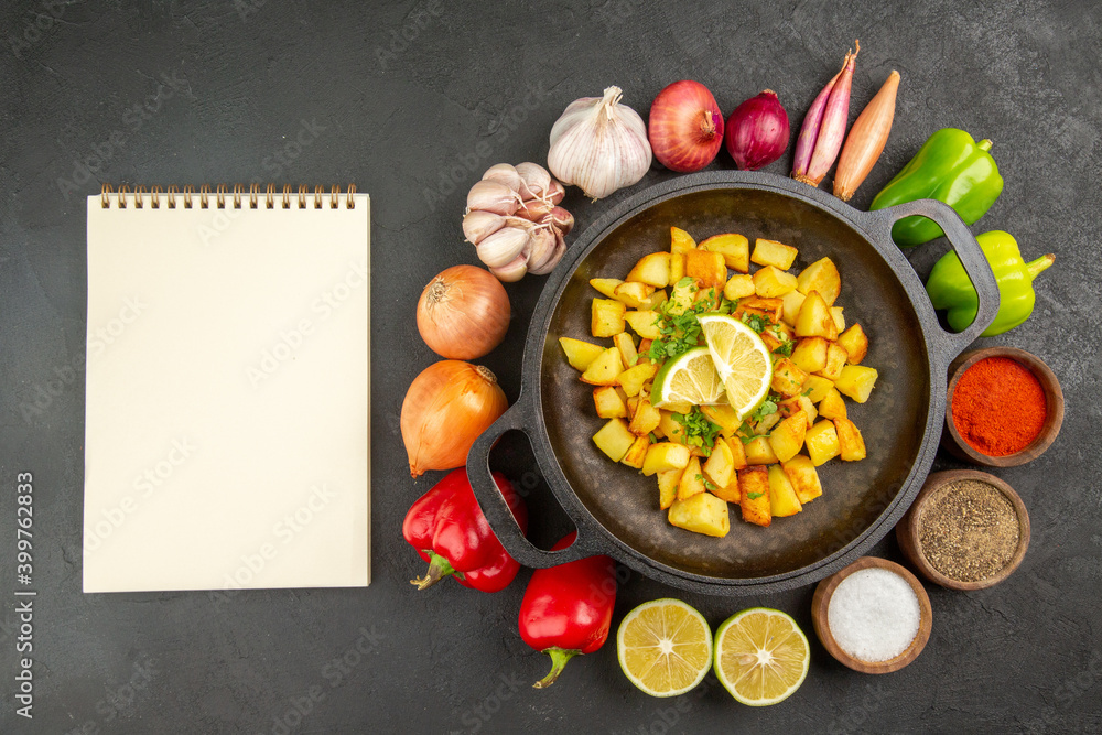 top view fried potatoes inside pan with different seasonings and vegetables on dark background cuisine meal food color pepper top view fried potatoes inside pan with different seasonings and vegetables on dark background cuisine meal food color pepper
