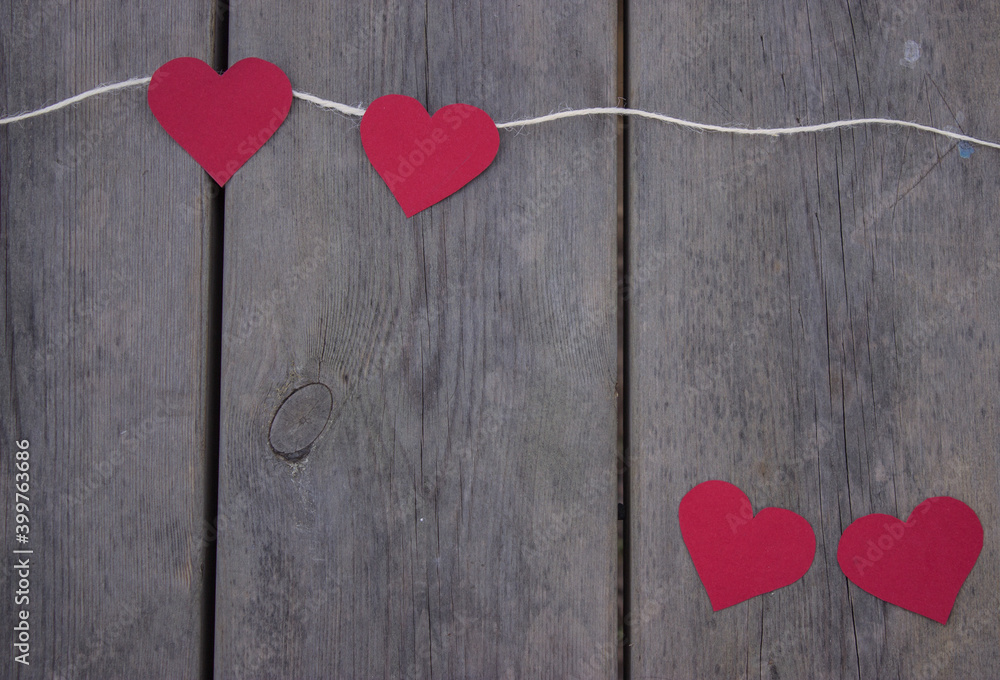 Top view red hearts on rope on a rustic wooden background. St Valentines day 2021. Place for text, copy space. Top view red hearts on rope on a rustic wooden background. St Valentines day 2021. Place for text, copy space.