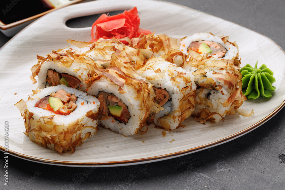 Sushi roll with tuna shavings on plate close up Sushi roll with tuna shavings on plate close up