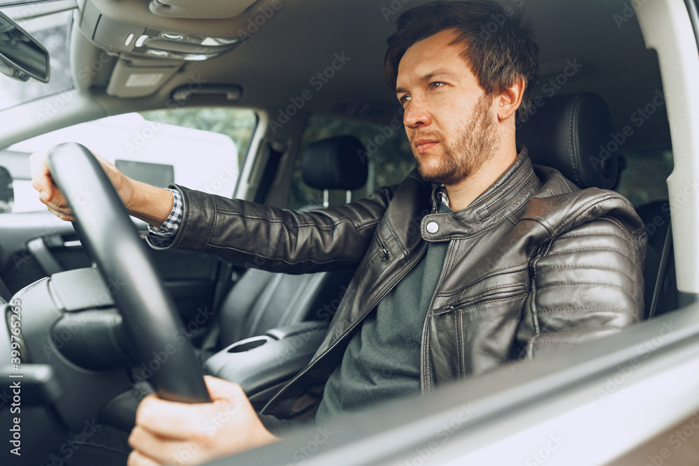 Confident young man sitting in a car Confident young man sitting in a car