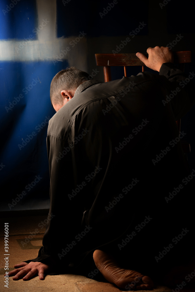Psychological portrait of a man. The man is sitting on the floor of the room. Back to the viewer. Reflects on the question. Psychological portrait of a man. The man is sitting on the floor of the room. Back to the viewer. Reflects on the question.