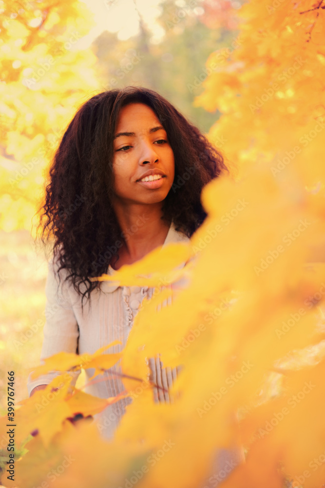 Young black woman relaxing in the autumn forest on a sunny day. Young black woman relaxing in the autumn forest on a sunny day.