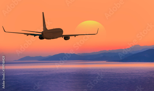 Airplane flying above tropical sea at amazing sunset © muratart