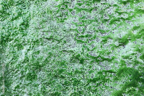 Closeup texture of old green paint on a concrete wall.