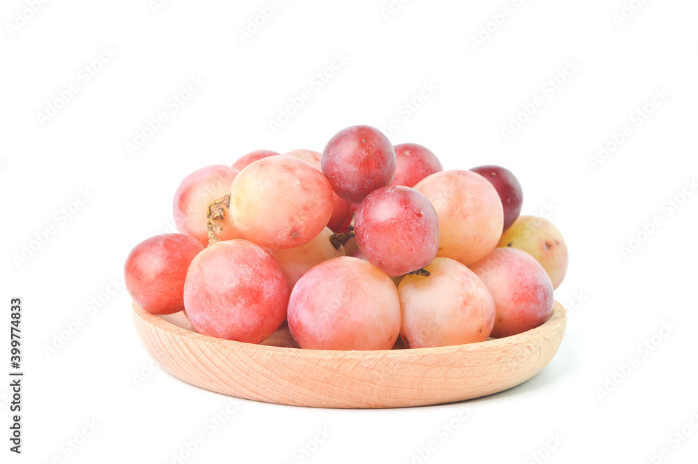 Bunch of fresh grape on wooden plate isolated on a white background. Bunch of fresh grape on wooden plate isolated on a white background.