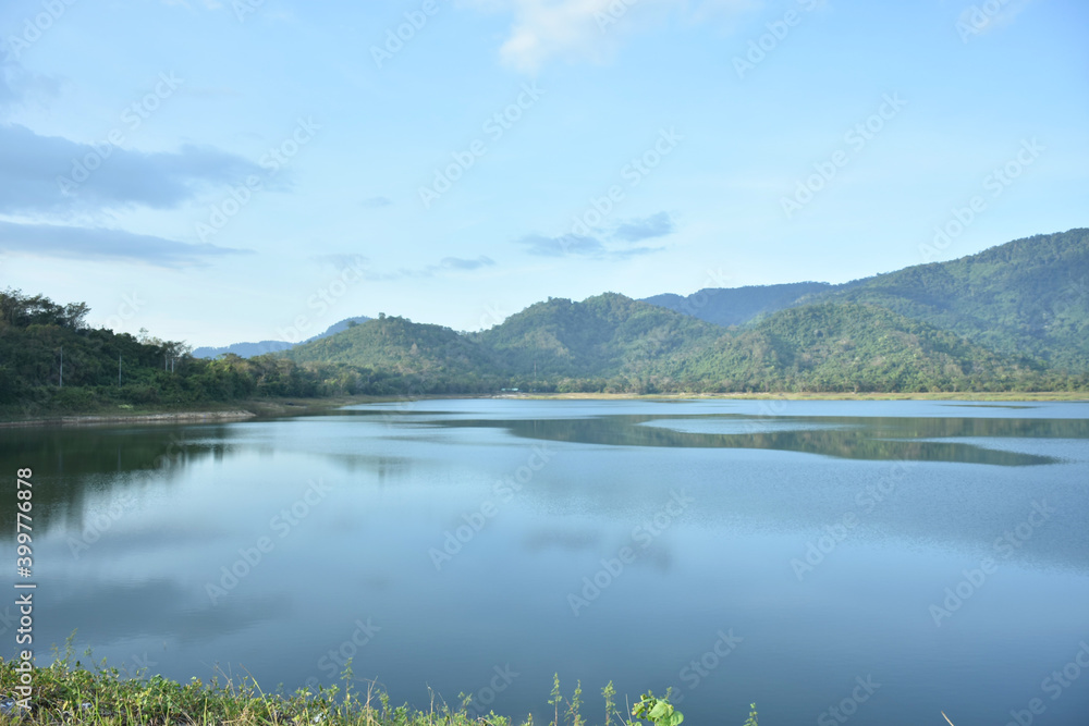 Beautiful sky and cloud with mountain reflection on water pond. Beauty view in countryside with mountain, water pool, and sky.
