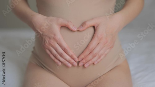 Wallpaper Mural Future mother petting abdomen and showing heart shape. Close up of woman pregnant belly. Concept of maternity, motherhood, pregnancy, love and family. Torontodigital.ca