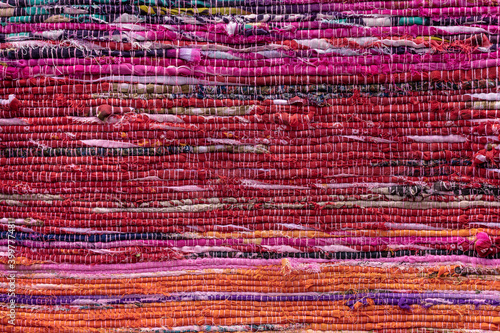 Cloth, typically produced by weaving or knitting textile fibers. Background and texture red old fabric