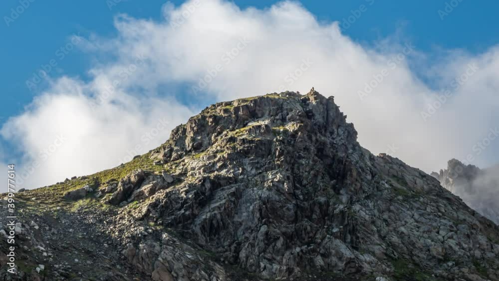 People climb to the top of the mountain against the background of clouds. Tourists have fun on the mountain. People climb to the top of the mountain against the background of clouds. Tourists have fun on the mountain.