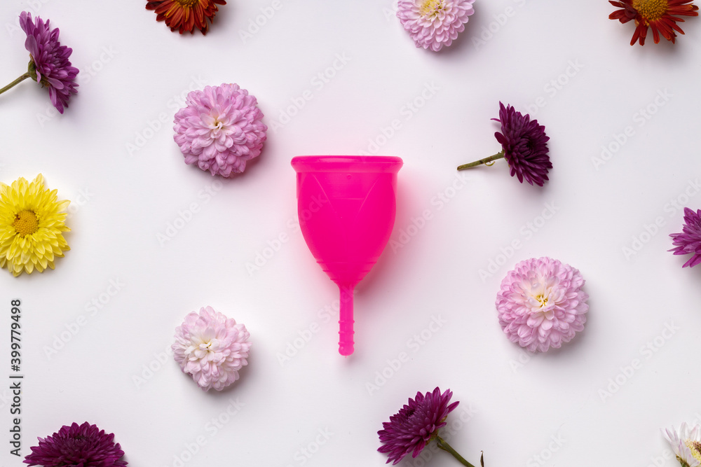Menstrual cup on floral pattern background top view Menstrual cup on floral pattern background top view