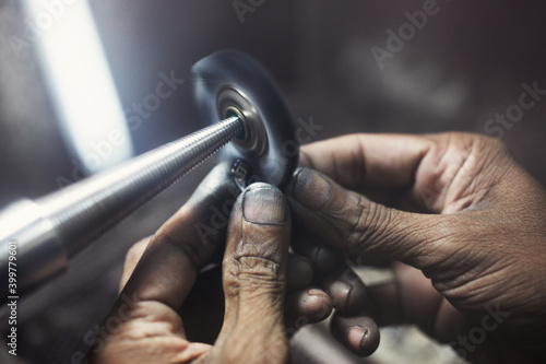 Closeup of jeweler hands polishing a ring.