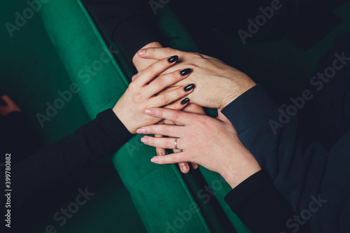 two man and three women holding hands on a table implying a polyamory relationship or love triangle. photo
