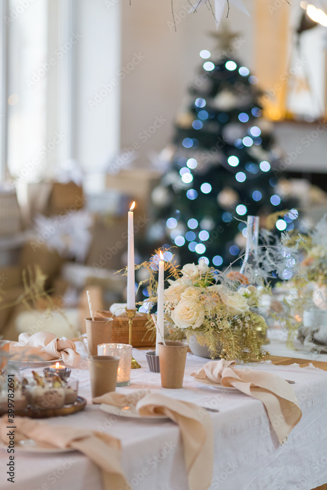 Christmas decoration of the festive table on the background of a Christmas tree with Christmas decorations