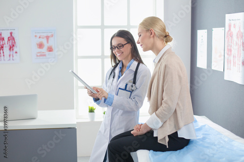 Doctor and patient discussing something while sitting at the table . Medicine and health care concept