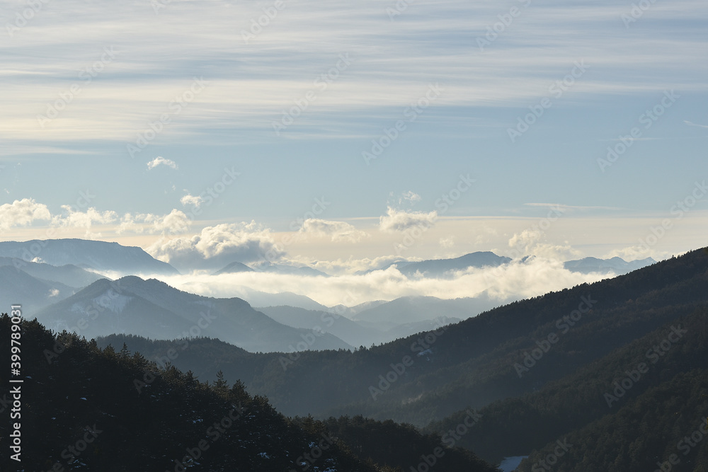 Nebelige Berglandschaft mit Wolken und Sonne, Horizont in der Weite sich verlierend
