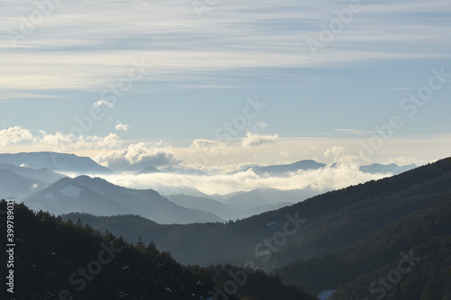 Nebelige Berglandschaft mit Wolken und Sonne, Horizont in der Weite sich verlierend