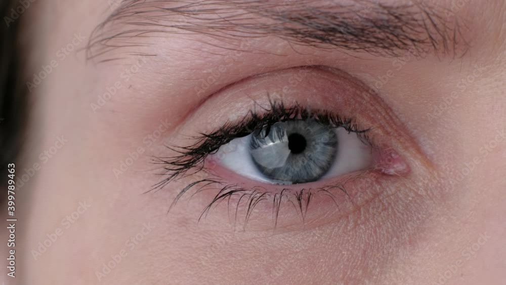 Beautiful constriction of the pupil. Extreme close up of a cute woman beautiful gray eye, she looking at camera. 4k. Concept of healthy vision. Beautiful constriction of the pupil. Extreme close up of a cute woman beautiful gray eye, she looking at camera. 4k. Concept of healthy vision.