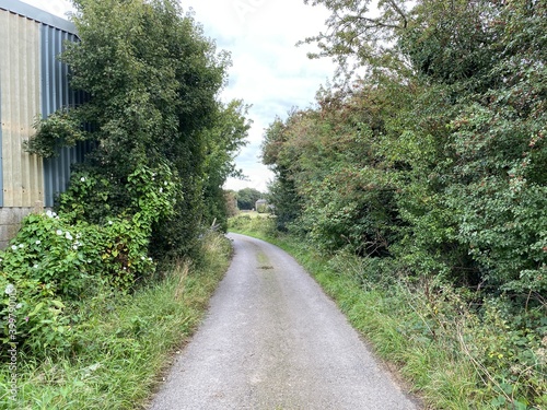 View past a large farm outbuilding, on Healey Croft Lane, on a cloudy day in, East Ardsley, Wakefield, UK photo