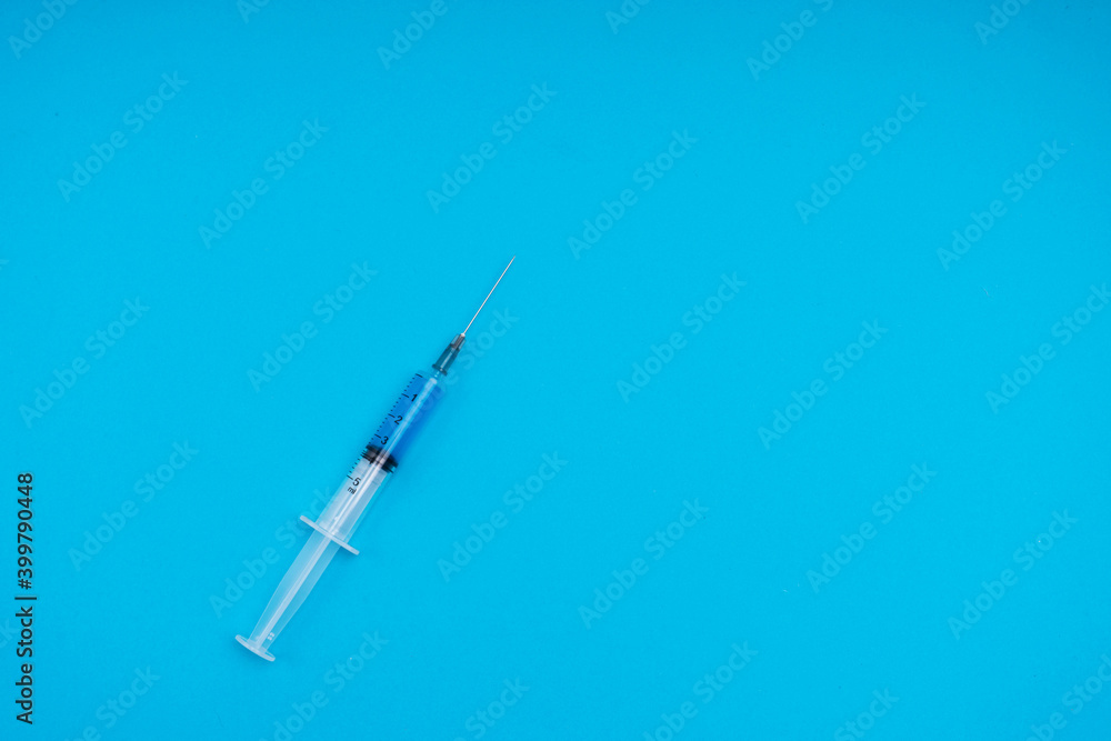 Medical syringe with vaccine on a blue background Medical syringe with vaccine on a blue background