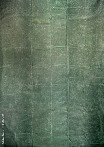Worn and distressed army surplus green canvas tarp background