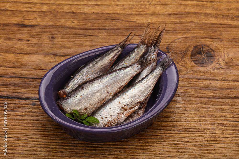 Anchovies in the bowl served basil leaves