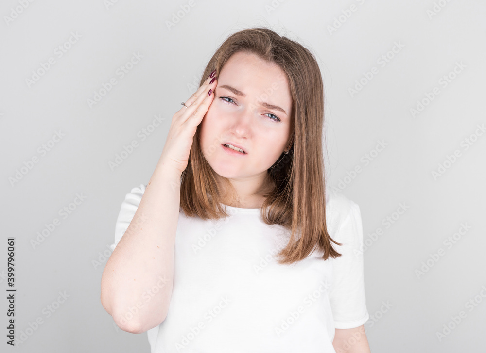 Young woman with a headache holds her temples with her hands. Health, migraine and headache concept. Young woman with a headache holds her temples with her hands. Health, migraine and headache concept.